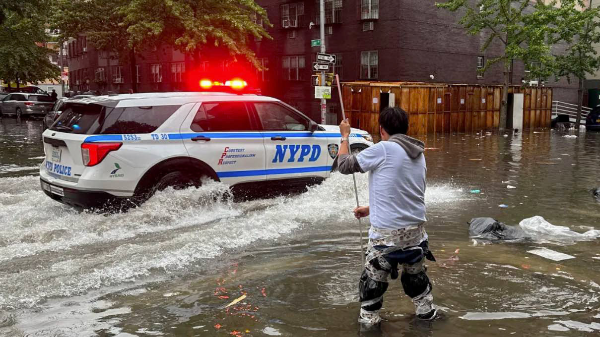 A man works to clear a drain in flood waters, Friday, Sept. 29, 2023, in the Brooklyn borough of New York. A potent rush-hour rainstorm has swamped the New York metropolitan area