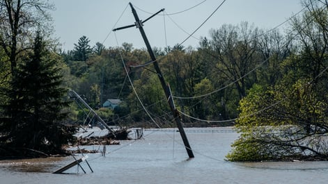 wires and poles surrounded by flooded waters