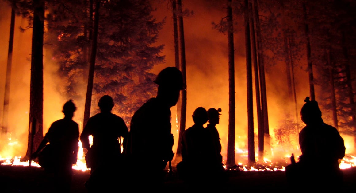 firefighters with wildfire in background