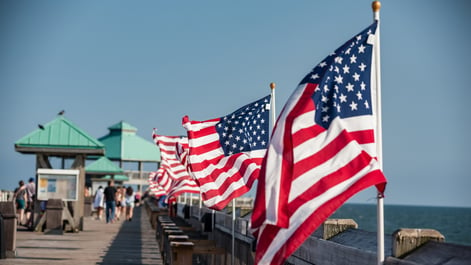 American Flags posted along a pier by the ocean