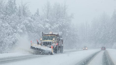 Snow plow removing snow off the road during a snow storm