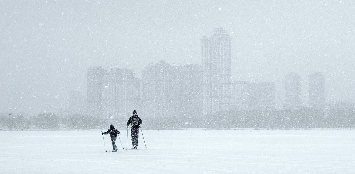 people in skis with skyline in background