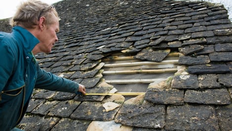 Roofer measuring damage 